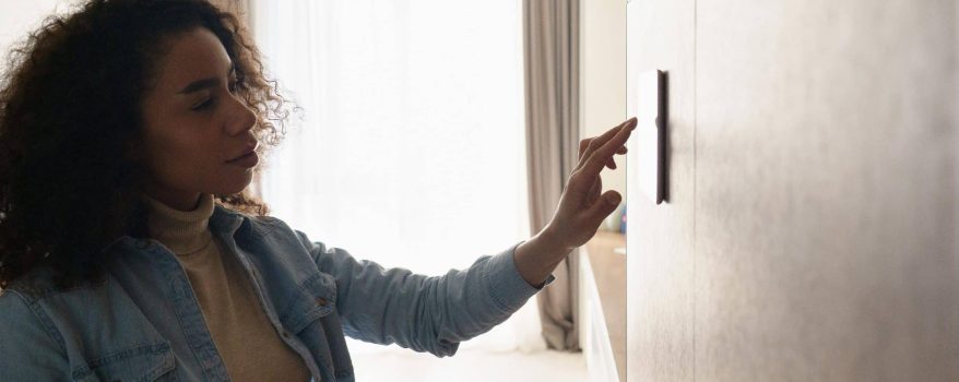 woman looking at thermostat confused